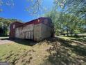 A concrete structure next to a barn with a red roof and some trees on a sunny day at 889 W Hightower Trail, Social Circle, GA 30025
