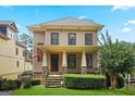 Charming two-story home with a well-manicured lawn and inviting front porch with stone accents at 3451 Fairway Dr, College Park, GA 30337