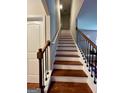 Elegant staircase with wooden steps and black metal railings, leading to the upper level at 301 Leland Ct, Mcdonough, GA 30253