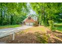 Brick home with a two-car garage, long driveway and mature landscaping at 70 Sylvia Cir, Covington, GA 30016