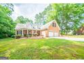 Well-maintained brick home with a two-car garage, manicured lawn, and mature landscaping at 70 Sylvia Cir, Covington, GA 30016