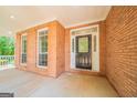 Covered front porch with brick facade, black front door and transom window at 70 Sylvia Cir, Covington, GA 30016