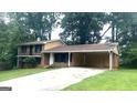 A split-level home with brick and siding, a covered carport, and a long driveway at 4196 Lehigh Blvd, Decatur, GA 30034