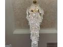 An elegant, tiered crystal chandelier hangs from a beautifully textured ceiling, adding luxury to the home at 1291 E M Croy Rd, Sugar Hill, GA 30518