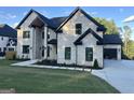 A two-story home boasts a well manicured lawn, a modern architectural style, and an attached garage at 1291 E M Croy Rd, Sugar Hill, GA 30518
