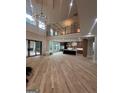 Bright open-concept living room with high ceilings, hardwood floors, and view into modern kitchen at 1293 E M Croy Rd, Sugar Hill, GA 30518