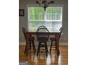 Dining room with a wooden table, four chairs and a window, complemented by hardwood floors at 2074 Ayers Creek Ct, Villa Rica, GA 30180