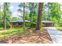 A spacious brick home with a long driveway and lush green lawn surrounded by mature trees at 3219 W Manor Ln, Atlanta, GA 30311