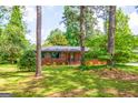 A spacious brick home with a long driveway and lush green lawn surrounded by mature trees at 3219 W Manor Ln, Atlanta, GA 30311