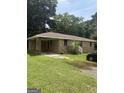 Brick home featuring a covered carport and a spacious front yard at 341 Boxwood St, Social Circle, GA 30025