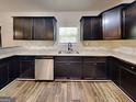 Well-lit kitchen with stainless steel appliances, dark wood cabinets, and ample counter space at 513 Cherry Creek Dr, Loganville, GA 30052