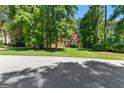 Beautiful brick home surrounded by mature trees and lush landscaping, offering a serene setting at 423 Holly Grove Church Rd, Peachtree City, GA 30269