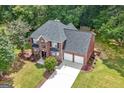 Aerial view of a brick two-story home with a well-manicured lawn and a two car garage at 1028 Gloria Grand Blvd, Mcdonough, GA 30252
