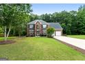 Beautifully landscaped two-story brick home with well-manicured lawn and a two car garage at 1028 Gloria Grand Blvd, Mcdonough, GA 30252