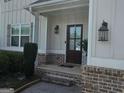 Inviting front entrance with brick accents, sconce lighting, and a wood door at 236 Villa Grande Dr, Locust Grove, GA 30248