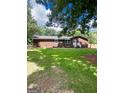 Brick home showcasing manicured front yard with vibrant green grass and blue shutters at 225 Second St, Bowdon, GA 30108
