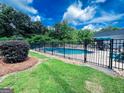 Backyard pool area enclosed by a black metal fence on a sunny day at 225 Second St, Bowdon, GA 30108