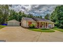 Charming single-story home with a large front yard and a detached two-car garage at 527 Malcom Rd, Covington, GA 30014