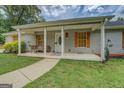 Cozy front porch with seating provides a welcoming entrance to this charming home at 527 Malcom Rd, Covington, GA 30014