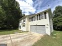 View of a two-story house featuring a two-car garage and a driveway at 2841 Heritage Ln, Morrow, GA 30260