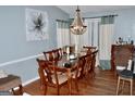 Formal dining room with hardwood floors, decorative chandelier, and seating for eight at 3253 Blackfoot Ln, Rex, GA 30273