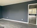 Spacious living room with dark gray walls and light gray wood-look flooring at 5793 Springfield Pl, Ellenwood, GA 30294