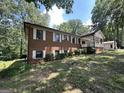 Two-story brick home featuring white shutters and a covered porch, surrounded by mature landscaping at 370 Rosetta Nw Ln, Conyers, GA 30012