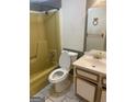 Bathroom features a tub, toilet, and vanity with outdated fixtures and tile flooring at 1308 Camelot Dr, South Fulton, GA 30349