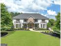 Attractive home with manicured lawn, stone accents, and double balconies providing classic curb appeal at 30 Dorset Ct, Sharpsburg, GA 30277