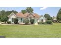 Inviting single-story home with manicured lawn, stone accents, and charming teal shutters at 115 Sunderland Cir, Fayetteville, GA 30215