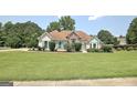 Inviting single-story home with manicured lawn, stone accents, and charming teal shutters at 115 Sunderland Cir, Fayetteville, GA 30215