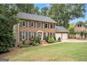 Two-story brick house with a manicured lawn, black shutters, and two-car garage at 1911 Geyser Trce, Lawrenceville, GA 30044