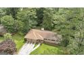 Aerial view of charming home with a two-car garage and surrounded by mature trees at 115 Club Cir, Stockbridge, GA 30281