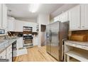 Well-lit kitchen with white cabinets, stainless steel appliances, and granite countertops at 2031 Dennis Pl, Buford, GA 30519