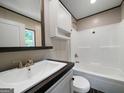 Bright bathroom featuring a vanity, mirror, toilet, and shower-tub combo at 273 Ridge Dr, Villa Rica, GA 30180