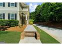 Inviting entryway with walkway to front door of home surrounded by trimmed shrubs and a well-maintained lawn at 397 Cypher Dr, Suwanee, GA 30024