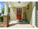 Charming front porch with a red door, decorated with seasonal wreaths and patriotic decorations at 397 Cypher Dr, Suwanee, GA 30024