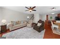Cozy living room featuring plush seating, a ceiling fan, and an open layout, perfect for relaxing and entertaining at 397 Cypher Dr, Suwanee, GA 30024