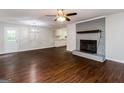 The spacious room showcases a painted brick fireplace, modern ceiling fan, and an open layout at 64 Acorn Dr, Dallas, GA 30157