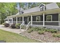 Charming home's front porch with white railings, well-kept landscaping, and a mix of greenery and stone accents at 270 Carrolls Way, Fayetteville, GA 30215