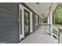 Inviting front porch with gray flooring and exterior, featuring a black front door and ample natural light at 270 Carrolls Way, Fayetteville, GA 30215