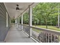 Spacious covered porch with white railings and views of the surrounding wooded landscape and lush greenery at 270 Carrolls Way, Fayetteville, GA 30215