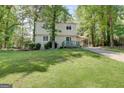 Two-story home with vinyl siding, a carport, and a well-maintained front lawn surrounded by mature trees at 405 Abbey Rd, Peachtree City, GA 30269