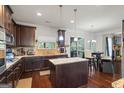 Modern kitchen featuring stainless steel appliances, granite countertops, dark wood cabinetry, and an island at 1492 Bourdon Bell Se Dr, Conyers, GA 30013