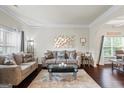 Cozy living room with crown molding, hardwood floors, stylish furniture, and lots of natural light at 1492 Bourdon Bell Se Dr, Conyers, GA 30013