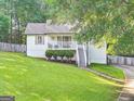 Charming home featuring manicured lawn, quaint front porch, and inviting stairway leading to the main entrance at 394 Thornbrooke Dr, Hiram, GA 30141