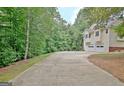 Long driveway leading to a two-car garage, surrounded by lush greenery at 4135 Coursey Lake Rd, Douglasville, GA 30135