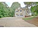 Two-story home with a two-car garage and ample parking space on a large driveway at 4135 Coursey Lake Rd, Douglasville, GA 30135