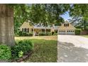 Charming yellow home featuring a lush front yard, covered porch, and an attached two car garage at 537 Country Lake Dr, Mcdonough, GA 30252