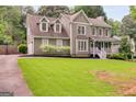 A spacious two-story home featuring a well-maintained lawn and an attached two-car garage at 90 Thomas Overby Dr, Sharpsburg, GA 30277